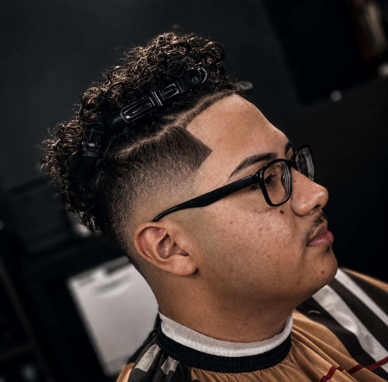 Curly top burst fade with hard part design
